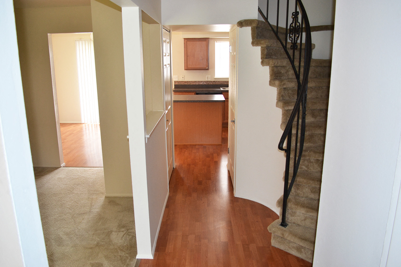 a view of a living room with a staircase and a kitchen